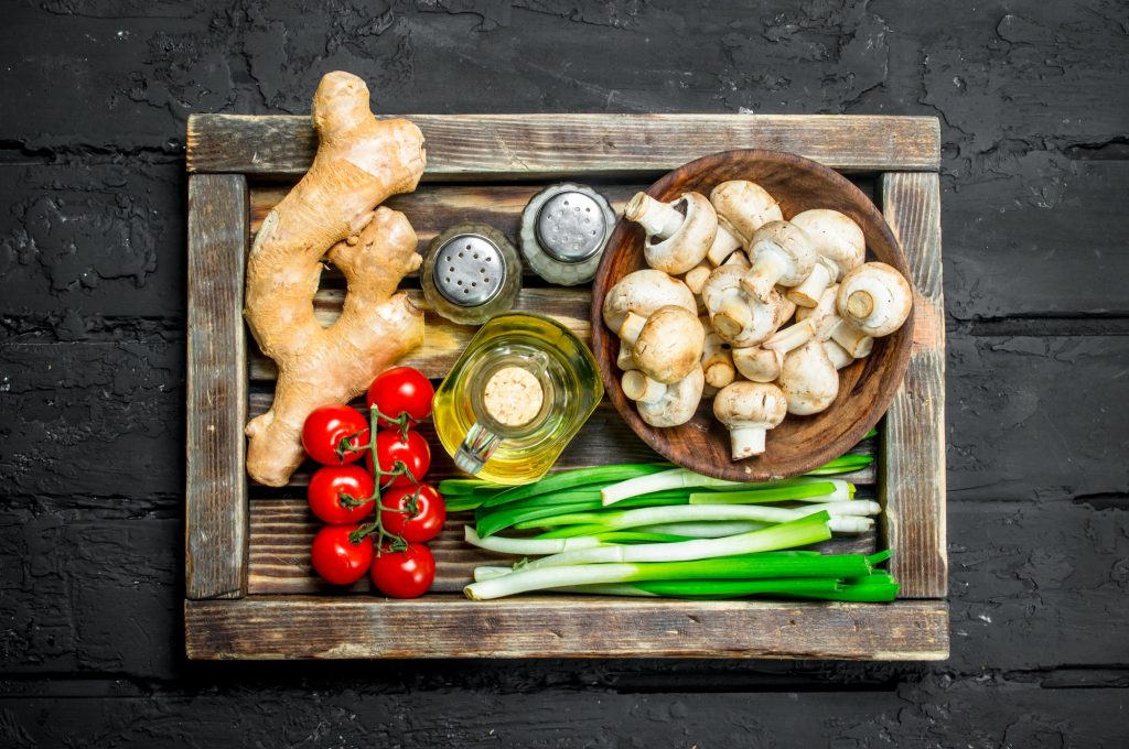 Organic food. Mushrooms with healthy vegetables in a wooden box.